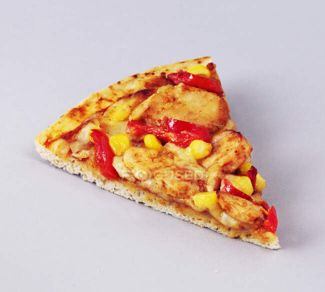 Una rebanada de pizza con pollo a la parrilla, pimientos y maíz - foto de stock