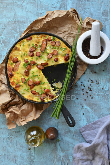 Paella dans une casserole avec pommes de terre, saucisses et ciboulette — Photo de stock