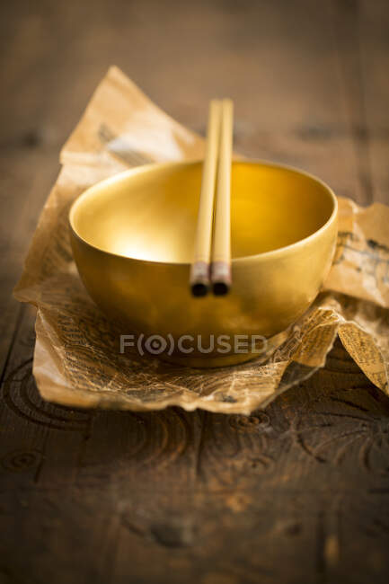 A golden bowl with chopsticks — Stock Photo