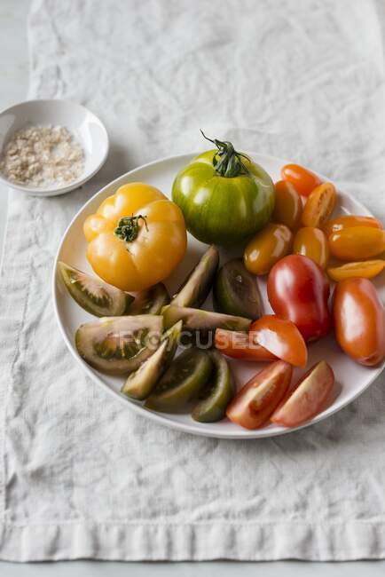 Una variedad de tomates en un plato - foto de stock