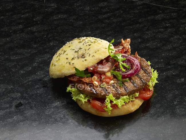 Nahaufnahme eines leckeren Hamburgers auf einem Kräuterbrötchen — Stockfoto