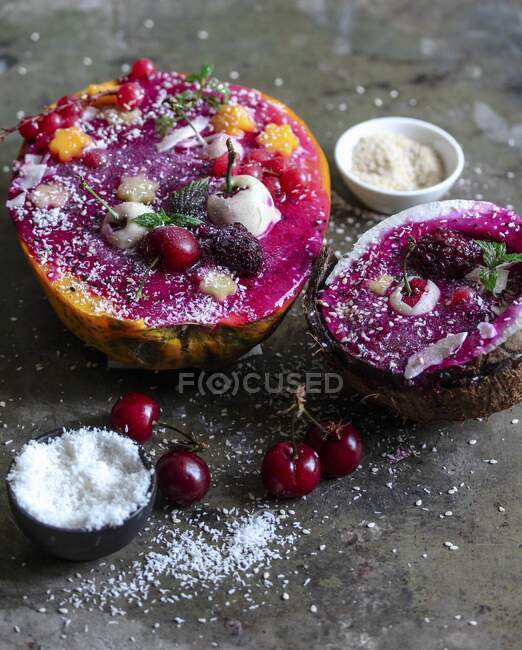 Smoothie bowls in melon and coconut halves — Stock Photo