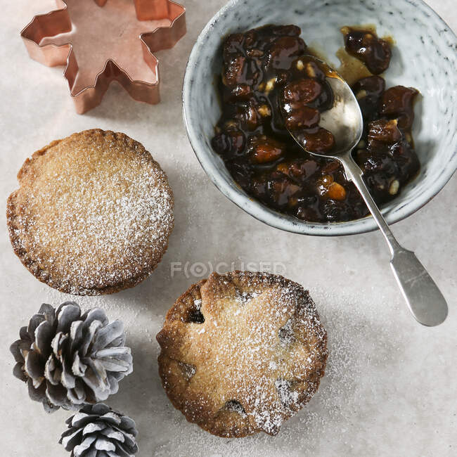 Mince pies, mince pie filling, a cookie cutter, and pine cones — Stock Photo