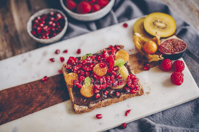 Torrada de pão integral com cobertura de chocolate, frutas e bagas — Fotografia de Stock