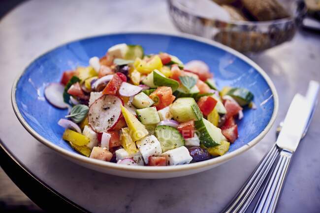 Greek salad on blue plate — Stock Photo