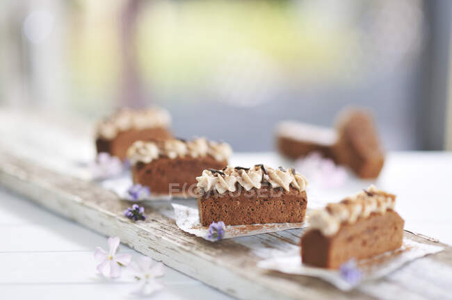 Mokka-Schokoladenkuchenscheiben mit Mandelcreme und Schokoladenchips auf einem Holzbrett (vegan)) — Stockfoto