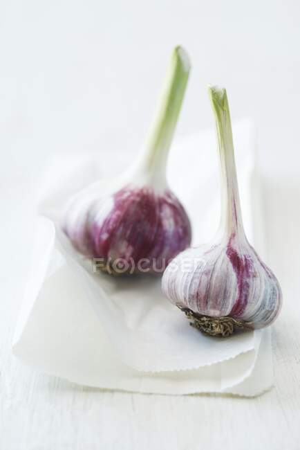 Due bulbi di aglio fresco su un sacchetto di carta — Foto stock