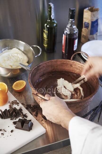 Mezcla gradualmente crema batida y chocolate derretido - foto de stock