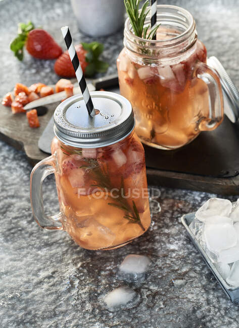 Two glasses of strawberry and rosemary switchel with ice cubes — Stock Photo