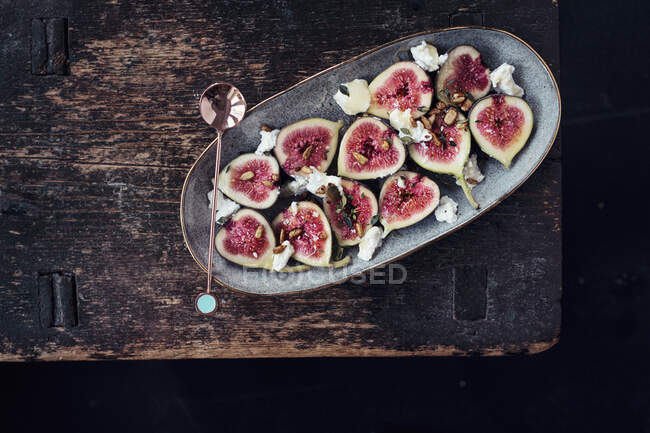 Fresh figs with thyme, honey, toasted seeds and ricotta cheese on ceramic plate with spoon — Stock Photo