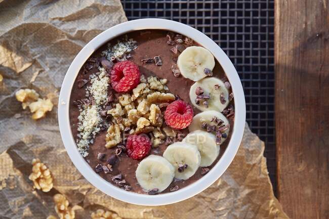 Um smoothie bowl com chocolate, banana, framboesas e nozes — Fotografia de Stock