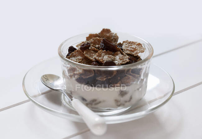 Bol de son de raisins avec lait et cuillère sur fond blanc — Photo de stock