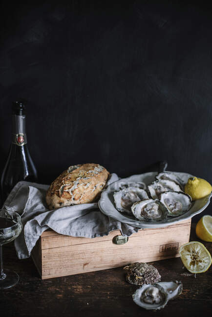 Свежие устрицы с лимонами и хлебом — стоковое фото