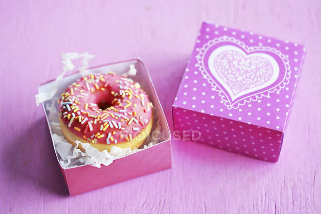 Mini rosquillas con glaseado y azúcar en una caja de regalo - foto de stock