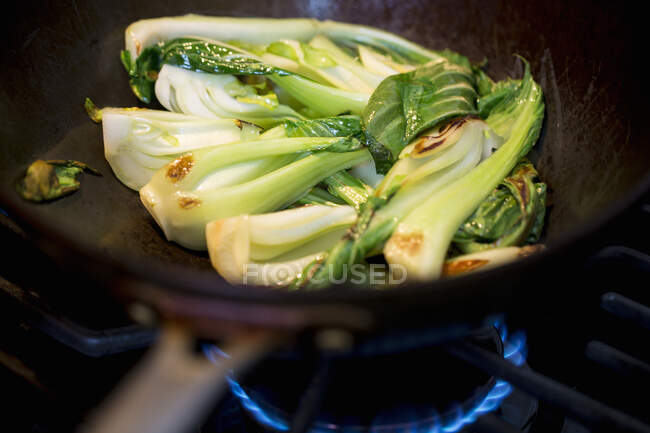 Fried bok choy in a wok — Stock Photo