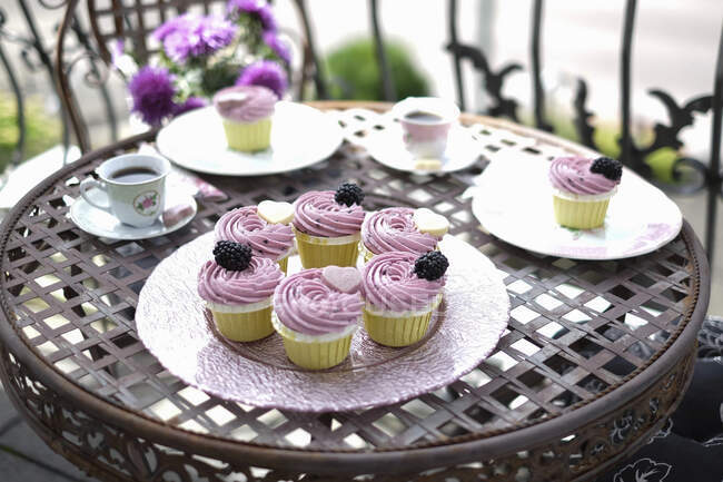 Cupcakes com amoras servidas na mesa da varanda — Fotografia de Stock
