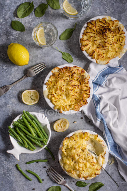 Individual fish pies with creamy cheesy mush potatoes and green beans — Stock Photo