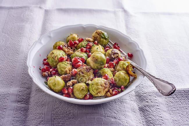 Brussel sprouts with pomegranate seeds and nuts — Stock Photo