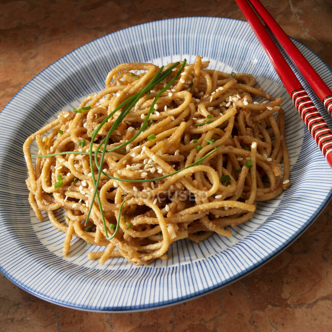 Sesame Peanut noodles with chive garnish — Stock Photo