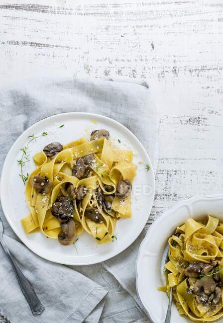 Pappardelle with mushrooms, nuts and thyme served on rustic tablecloth — Stock Photo