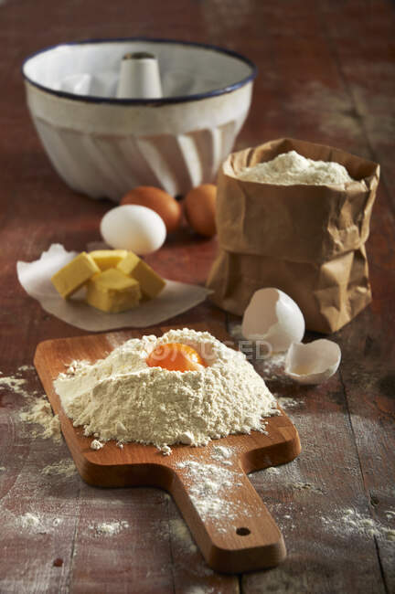Flour, eggs, butter and a ring-shaped baking tin for a Bundt cake — Stock Photo
