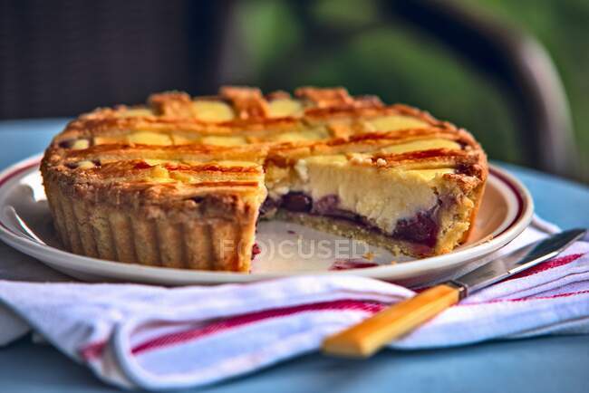 A cherry and ricotta tart with a slice cut out — Stock Photo