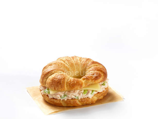 Un croissant lleno de ensalada de atún y queso - foto de stock