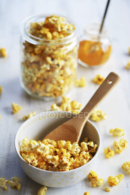 Popcorn au curry et sel dans un bol et un bocal — Photo de stock
