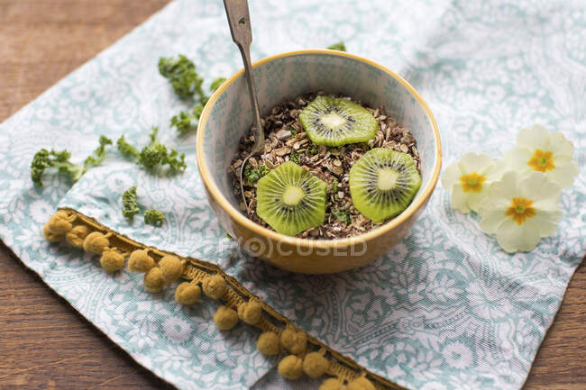 Bowl of muesli with kiwi and kale — Stock Photo
