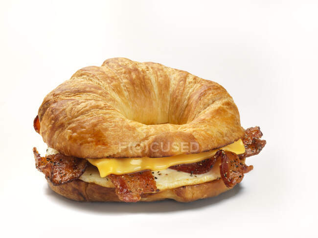 Bagel de croissant con tocino, huevo frito y queso - foto de stock