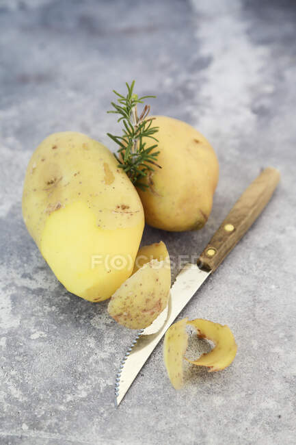 Почистить картошку и розмарин — стоковое фото