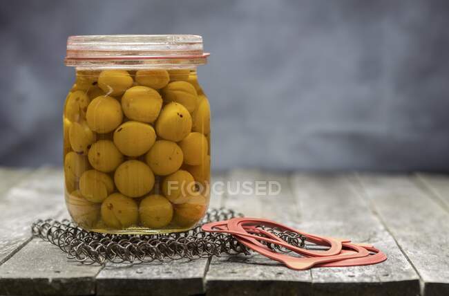 Preserved small yellow plums in a glass jar — Stock Photo