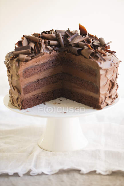 Un pastel de crema de chocolate de tres capas, en rodajas - foto de stock