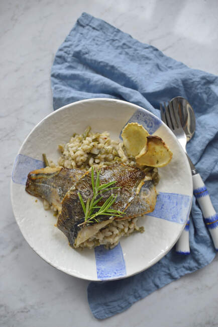 Fried fish fillets on risotto with green beans — Stock Photo