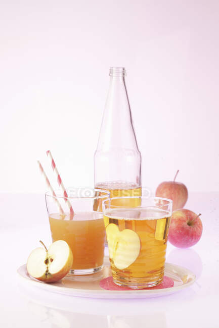 Яблучний сік у пляшці та окулярах зі свіжими яблуками — стокове фото