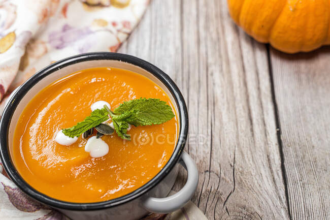 Zuppa di zucca cremosa fatta in casa con menta in una pentola di smalto — Foto stock