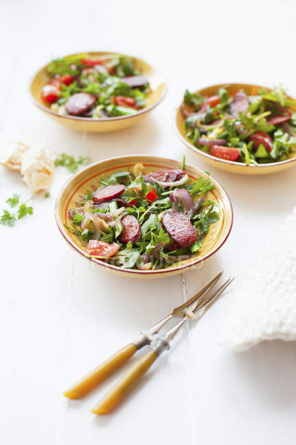 Rocket salad with green beans, chorizo, cherry tomatoes and red onions — Stock Photo