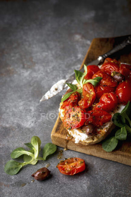 Sandwich de masa fermentada de tomate con ricotta y aceitunas - foto de stock