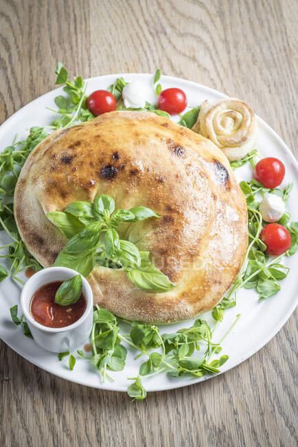 Tortellone Pizza gefüllt mit frischem Salat, Kirschtomaten, Mozzarella mit Tomatensauce — Stockfoto