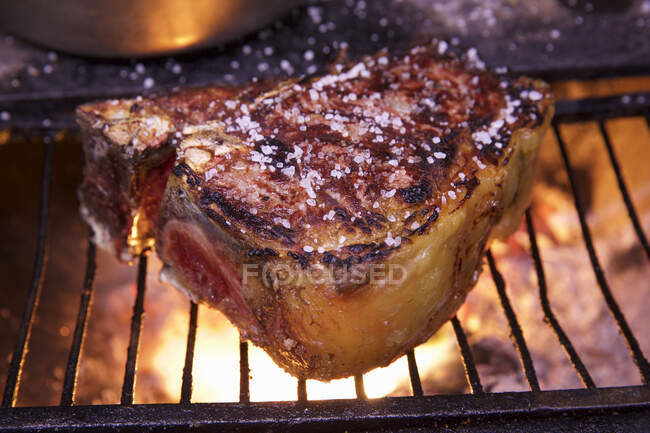 Um bife salgado em uma grelha — Fotografia de Stock