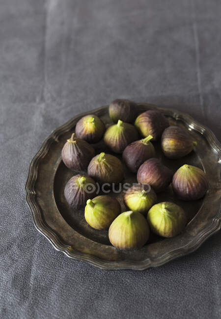 Fresh figs on metal plate and on gray tablecloth — Stock Photo