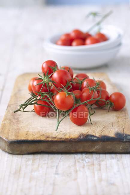 Tomates cereja em uma tábua de corte de madeira — Fotografia de Stock