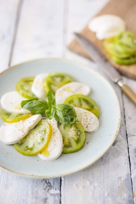 Caprese with green tomatoes and basil — Stock Photo