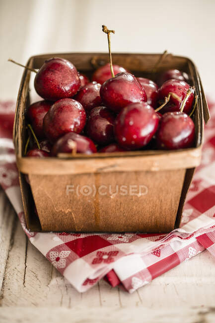 Cerejas frescas em uma cesta de madeira — Fotografia de Stock