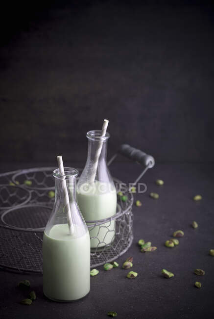 Homemade pistachio milk with straws in bottles — Stock Photo