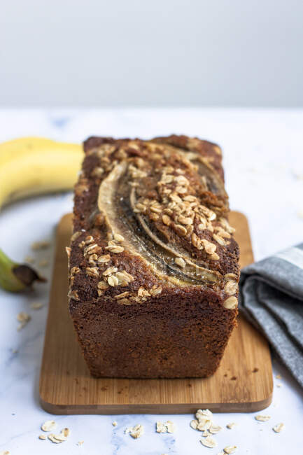 Whole meal banana bread with oats on wooden board — Stock Photo