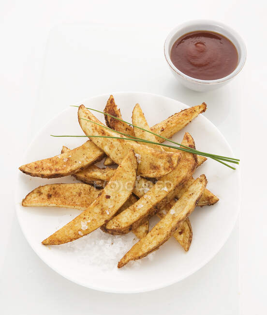 Kartoffelkeile mit Paprika belegt, mit Meersalz und Schnittlauch bestreut, Tomatensauce beidseitig — Stockfoto