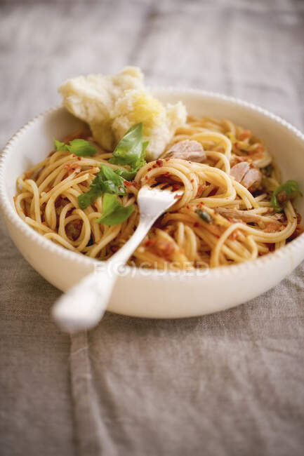 Pasta with tuna fish and tomatoes and fork in bowl — Stock Photo