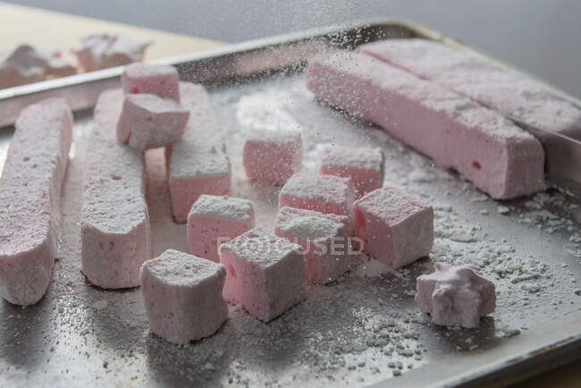Malvaviscos rosados con azúcar en polvo que cae - foto de stock
