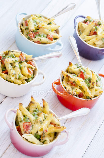 Mini servings of pasta bake with peas, cherry tomatoes in creamy white sauce — Stock Photo